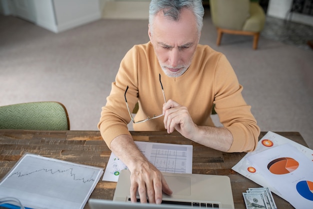 A person looking thoughtfully at a graph showing increasing Social Security benefits with age. The graph should emphasize the financial advantage of delaying benefits until age 70.